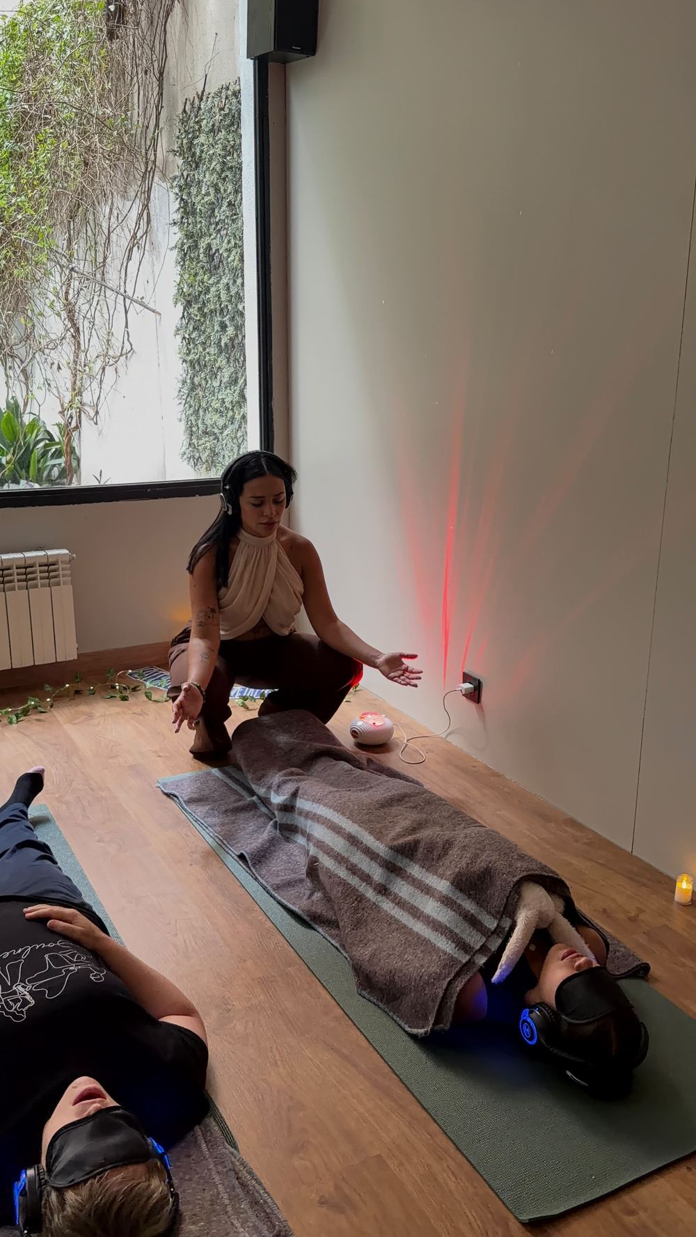 Yoana acompañando a un participante bajo una manta